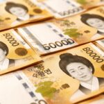 Notas de dinheiro sul-coreano espalhadas sobre uma superfície limpa.